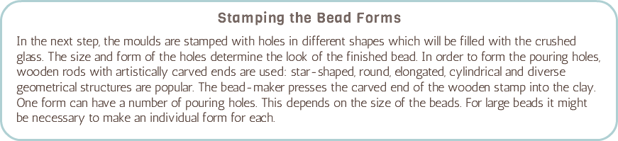 Stamping the Bead Forms In the next step, the moulds are stamped with holes in different shapes which will be filled with the crushed glass. The size and form of the holes determine the look of the finished bead. In order to form the pouring holes, wooden rods with artistically carved ends are used: star-shaped, round, elongated, cylindrical and diverse geometrical structures are popular. The bead-maker presses the carved end of the wooden stamp into the clay. One form can have a number of pouring holes. This depends on the size of the beads. For large beads it might be necessary to make an individual form for each. 
